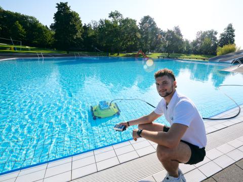 Fachangestellter für Bäderbetriebe reinigt ein Schwimmbecken